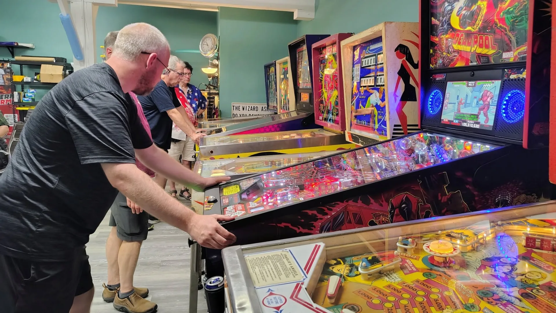 Players enjoying a row of pinball machines at the club